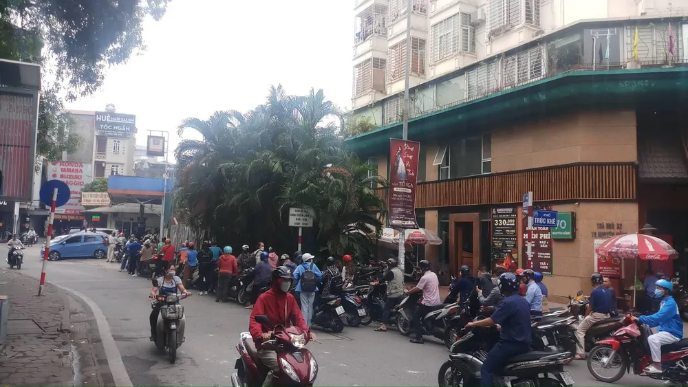 Người dân Hà Nội xếp hàng dài chờ đổ xăng sáng 11-11. Ảnh: AH