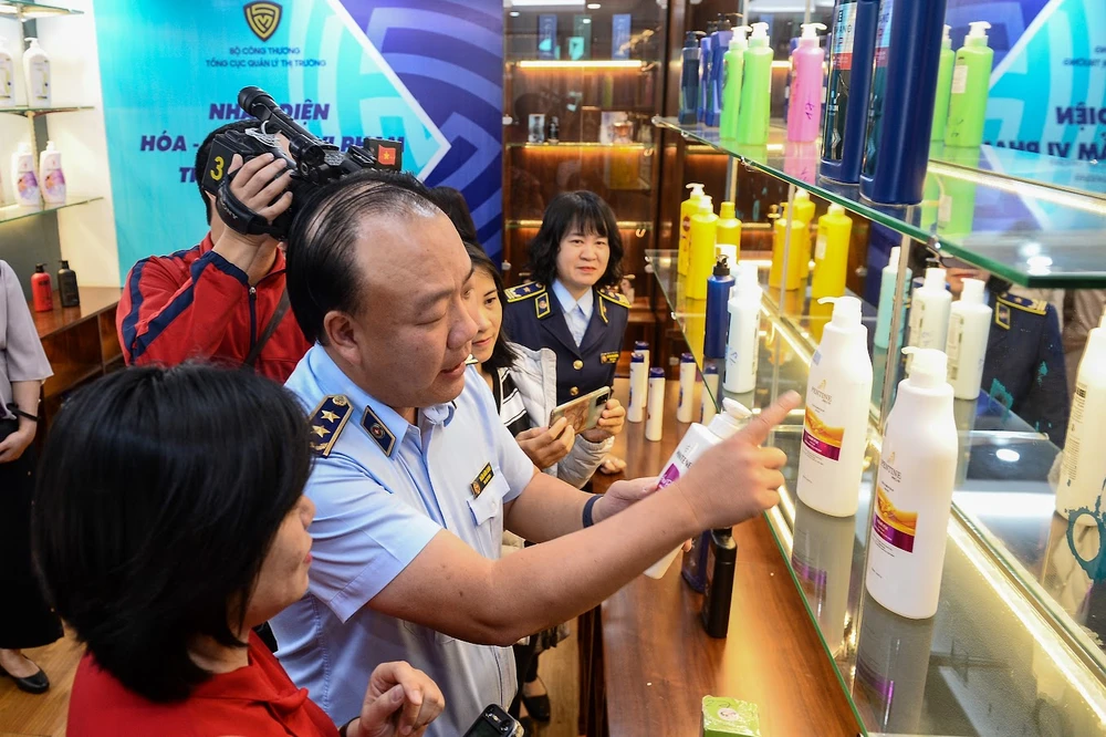 Ông Trần Hữu Linh, Tổng cục trưởng Tổng cục Quản lý thị trường hướng dẫn cách phân biệt mỹ phẩm thật và hàng vi phạm. Ảnh: DMS