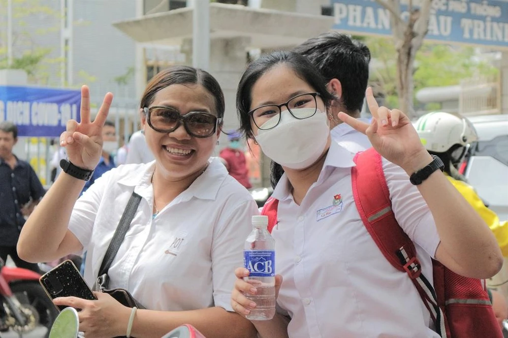 Một thí sinh vui vẻ chụp ảnh với mẹ sau khi hoàn thành tốt bài thi đầu tiên. Ảnh: T.AN