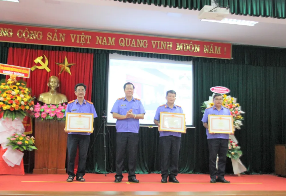 Phó Viện trưởng VKSND Tối cao Nguyễn Quang Dũng trao Bằng khen của Thủ tướng Chính phủ cho ông Nguyễn Văn Hưng (Chánh Văn phòng VKSND TP Đà Nẵng), ông Nguyễn Phước Toán (Viện trưởng VKSND quận Hải Châu) và ông Lê Viết Sỹ (Phó Viện trưởng VKSND quận Hải Châu). Ảnh: TA
