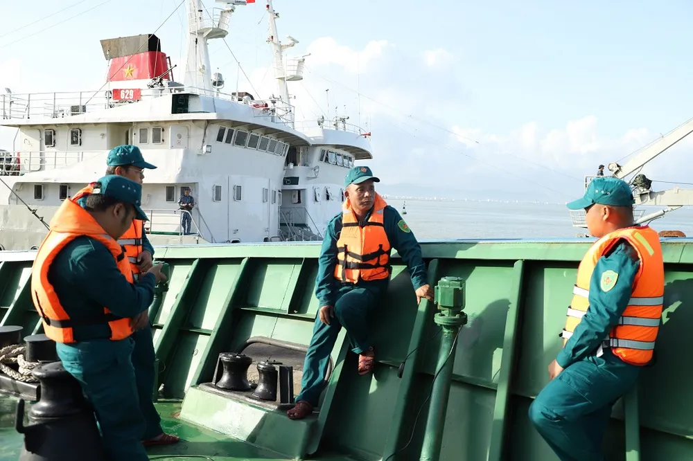 Anh Đinh Công Vương (đứng giữa) đang chia sẻ những kinh nghiệm sóng gió với anh em trên tàu ĐNa 91218TS. Ảnh: HOÀNG DIỆU