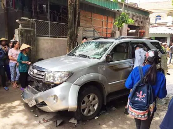 Chiếc xe hơi bị xịt lốp, đập vỡ kính, hỏng phần nhựa phía trước, móp vỏ xe.