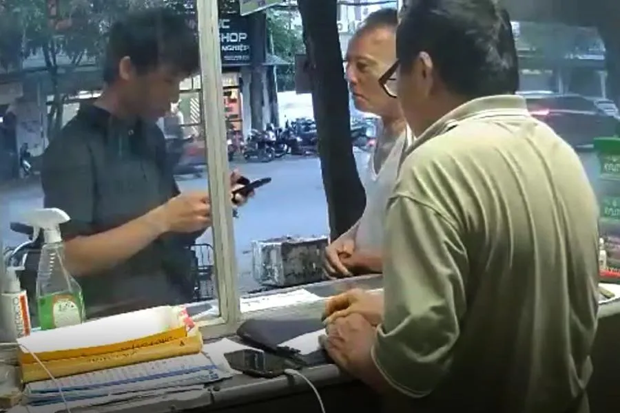 Hoàng (bìa trái) đến hỏi mua 4 thẻ cào điện thoại. Ảnh cắt từ video clip. Hoàng (bìa trái) đến hỏi mua 4 thẻ cào điện thoại. Ảnh cắt từ video clip.