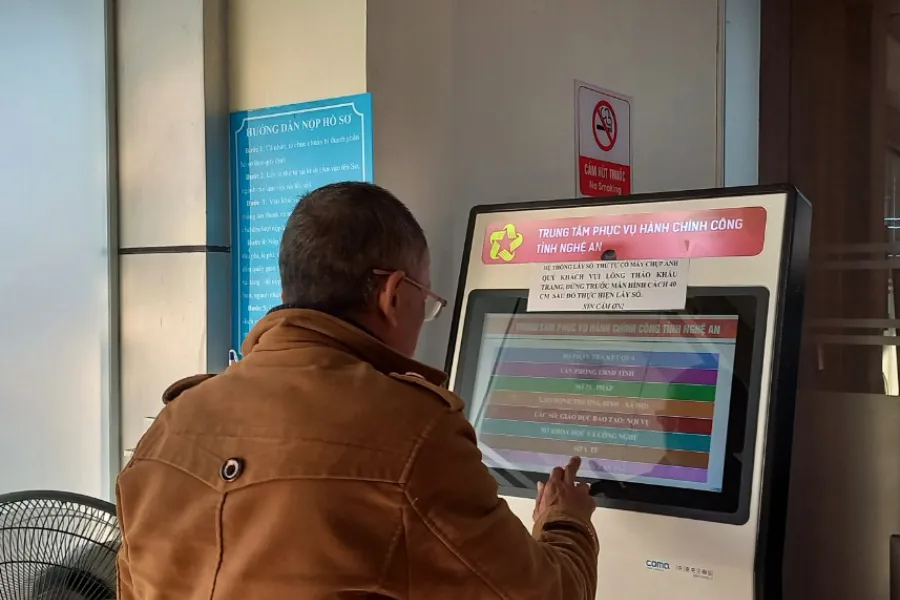 Ông Trần Mạnh Hoài (61 tuổi, trú phường Vinh Tân, TP Vinh) đến Trung tâm phục vụ hành chính công tỉnh Nghệ An bấm lấy số thứ tự để làm thủ tục cấp đổi giấy phép lái xe.