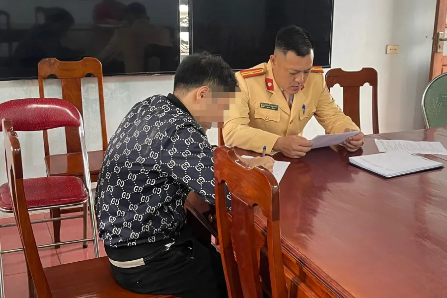 Tài xế LXQ làm việc với CSGT. Ảnh: CA