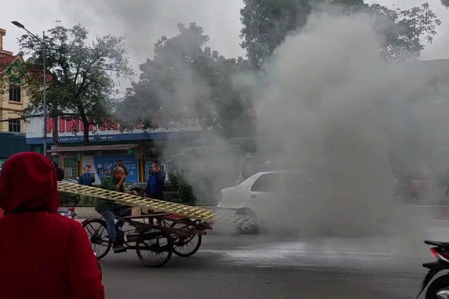 Khói trắng từ xe bốc lên, người dân phải dùng tay bịt mũi.