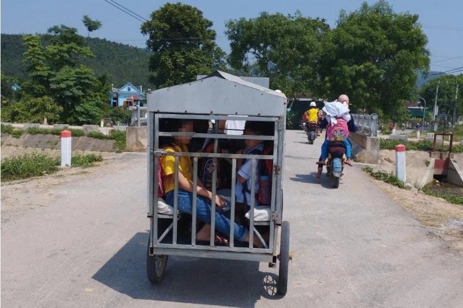 Thùng xe tự chế được kéo bằng xe máy chở các học sinh đi học được tránh nắng nóng. Ảnh: NA. Thùng xe tự chế được kéo bằng xe máy chở các học sinh đi học được tránh nắng nóng. Ảnh: NA.