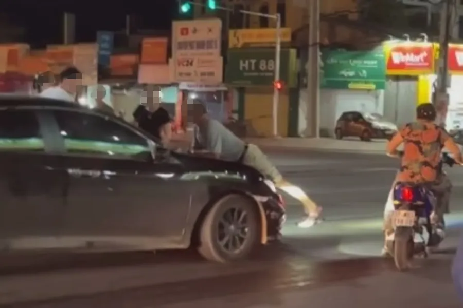 Chiếc xe hơi di chuyển khi người đàn ông đang nằm úp trên capo.