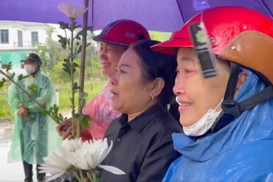 Người dân đứng rưng rưng khóc dưới mưa đón linh cữu Đại úy liệt sĩ Lê Ánh Sáng.