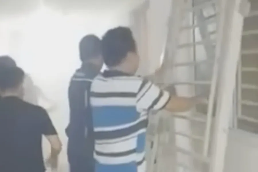 Người dân nỗ lực tháo cánh cửa căn hộ để dập lửa. chay-chung-cu.jpg