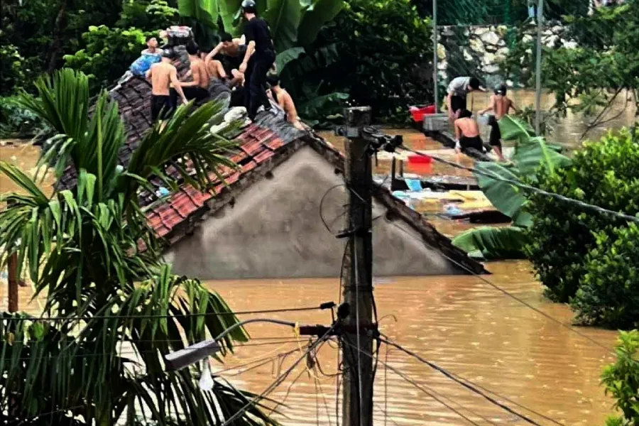 Nước lũ dâng quá nhanh, học sinh Trường THPT Quỳ Châu (Nghệ An) phải leo lên nóc nhà chờ cứu. Ảnh: T.ĐẠT hoc-sinh-quy-chau.jpg