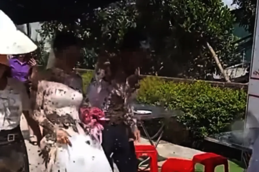 Cô dâu, chú rể bị tạt chất bẩn ngay trước cổng hôn trường. Ảnh: Cắt từ video clip tat-chat-ban-vao-co-dau.jpg