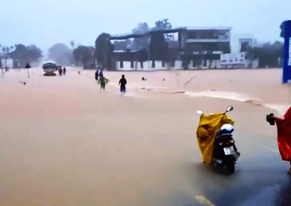 Đầu giờ chiều 30-10, người dân chạy ra cứu một người đi xe máy bị nước lũ cuốn trôi đoạn qua xã Phúc Đồng (huyện Hương Khê, Hà Tĩnh). troi-xe-2981-8035.png