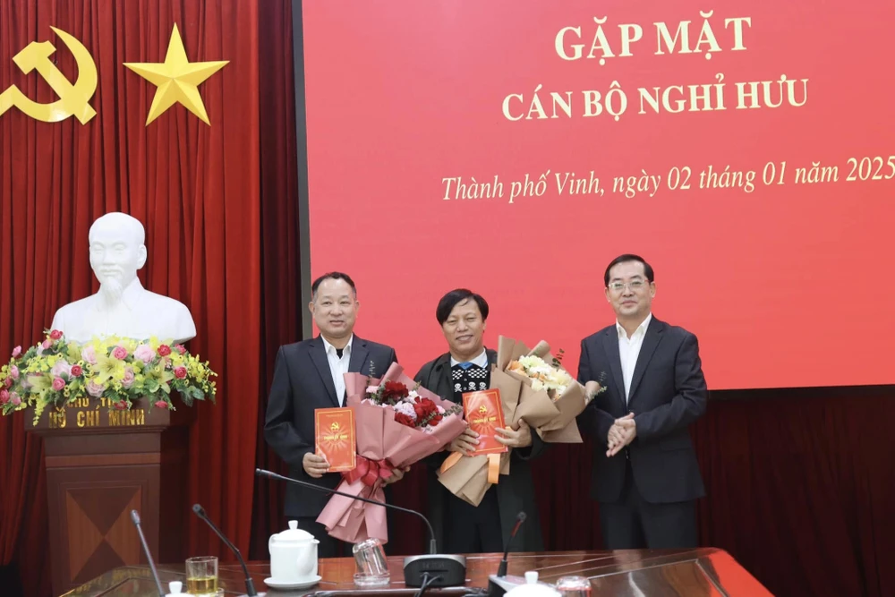 Ông Nguyễn Văn Lư, Phó Bí thư Thành ủy Vinh tặng hoa và trao quyết định nghỉ hưu trước tuổi cho ông Phạm Trung Thành và ông Lê Đức Thọ. Ảnh: HL.