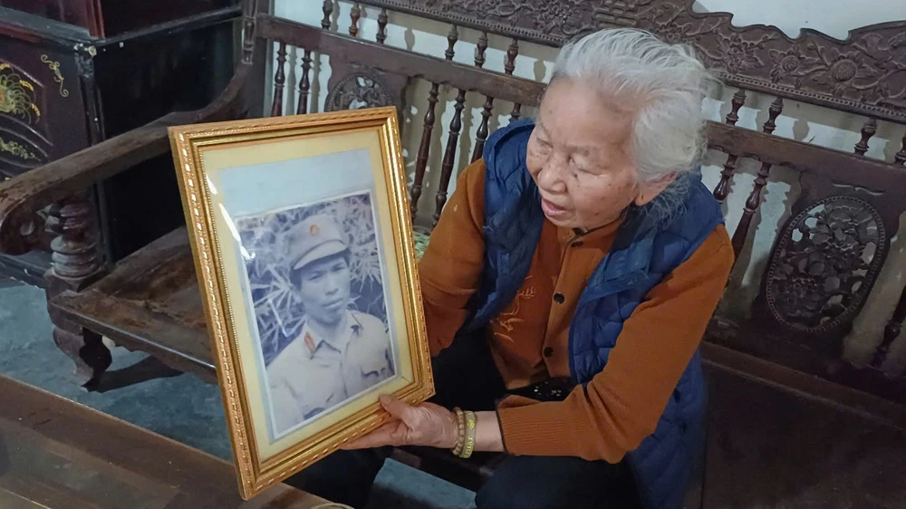 Bà Đặng Thị Tuyên và di ảnh chồng là ông Thái Bá Minh - pháo thủ số 1 trên xe tăng 843. Thai-Ba-Minh.jpg
