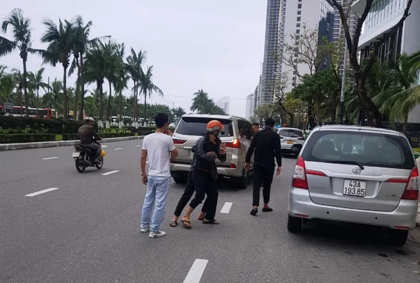 Anh Q (đội nón bảo hiểm) bị nhóm đi trên ô tô khống chế. Ảnh: Cắt từ clip Anh Q (đội nón bảo hiểm) bị nhóm đi trên ô tô khống chế. Ảnh: Cắt từ clip