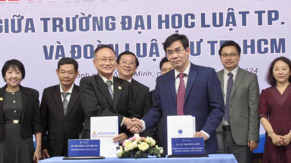 Hai bên ký kết biên bản hợp tác. Ảnh: YC Truong-DH-Luat-TP.HCM.jpg