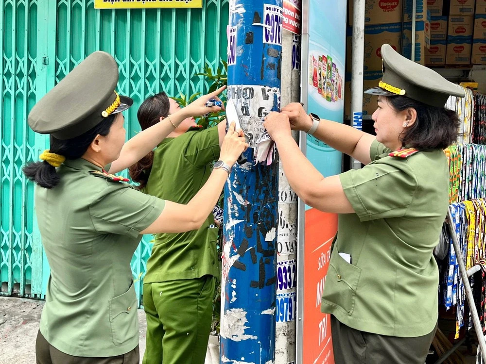 Cán bộ bóc gỡ, xóa bỏ các quảng cáo sai quy định trên tường nhà, cột điện... Ảnh: CA luat-quang-cao-hinh-minh-hoa.jpg