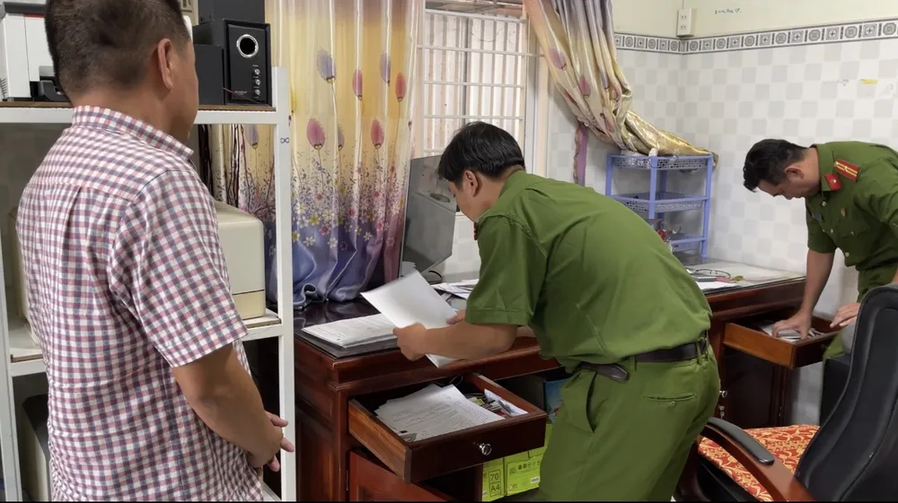 Công an khám xét và thu giữ hồ sơ, tài liệu tại nhà bị can Hùng ở Bến Tre. Ảnh: CHÂU ANH