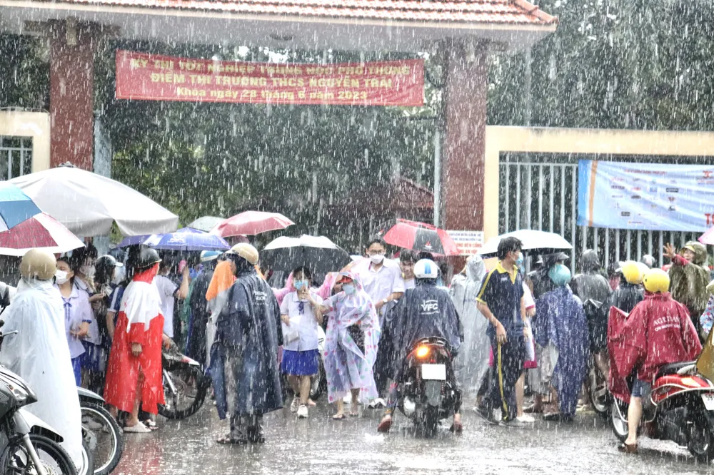 Vừa thi xong môn Toán, thí sinh đã có ô dù che chắn vì mưa lớn ảnh 3