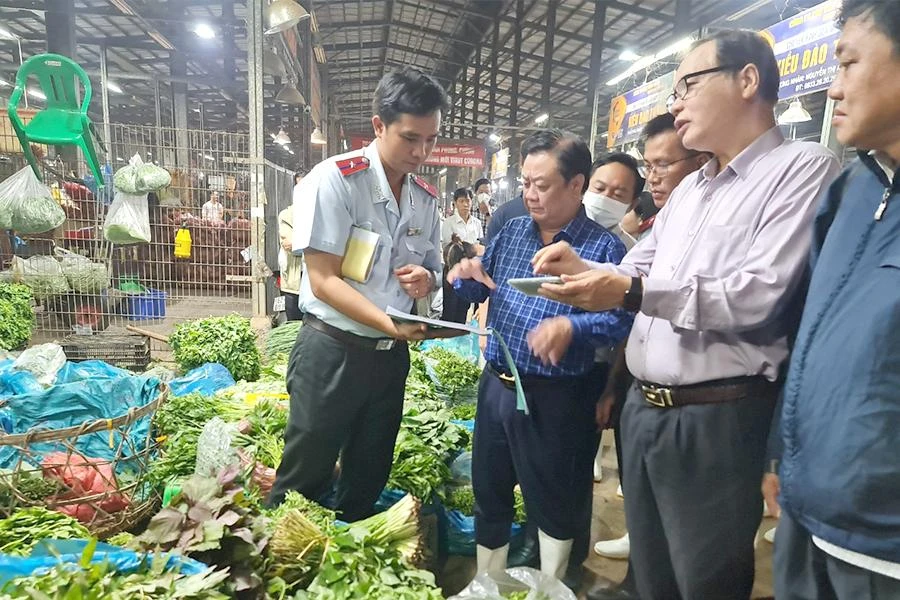 Bộ trưởng Bộ NN&amp;PTNT khảo sát thực tế tại chợ Bình Điền rạng sáng 17-10. Ảnh: NGUYỄN CHÂU