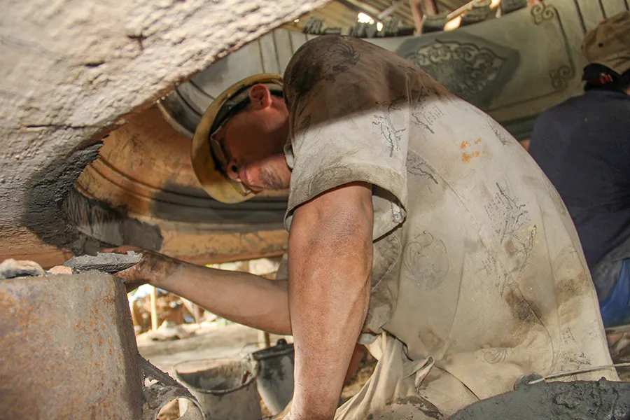 Các nghệ nhân ở làng đúc đồng Phường Đúc đang khẩn trương làm các sản phẩm. Ảnh: NGUYỄN DO