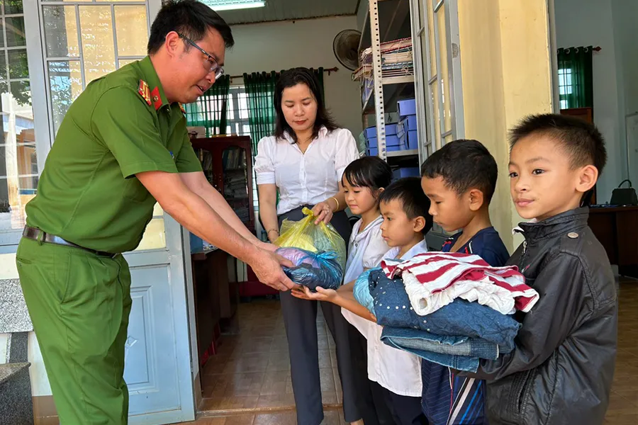 Trung tá Nguyễn Hồng Kiên (phải) cùng các mạnh thường quân tặng đồ cho học sinh Trường Tiểu học Bi Năng Tắc. Ảnh: VŨ LONG
