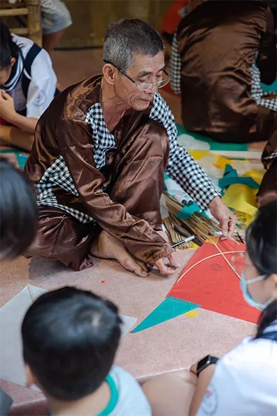 Nghệ nhân Nguyễn Thanh Vân truyền nghề làm diều cho lớp trẻ. Ảnh: NVCC