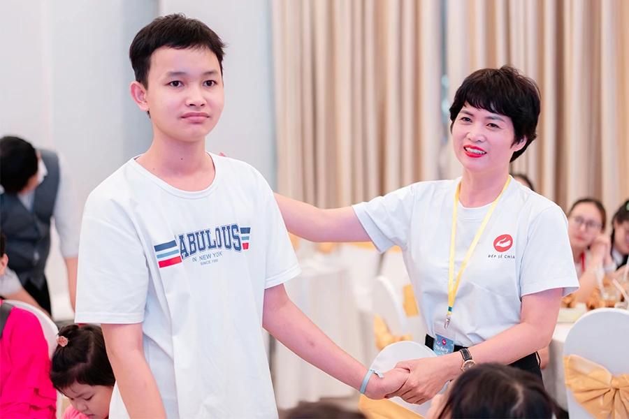 Chị Lê Tường Vy gặp lại Từ Ngọc Quý trong chương trình Yêu thương và hy vọng do nhóm thiện nguyện Bếp sẻ chia nhằm tạo cơ hội để gần 100 trẻ từng mắc ung thư và đã khỏi bệnh từ 5-10 năm gặp gỡ, vui chơi tại Công viên văn hóa Đầm Sen (TP.HCM), tối 15-7. Ảnh: THẢO PHƯƠNG