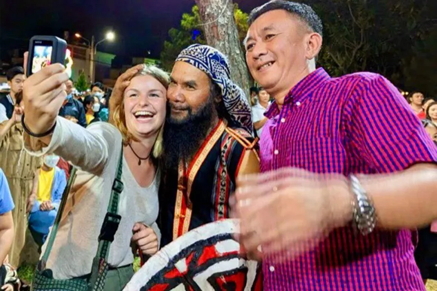 Du khách chụp ảnh lưu niệm cùng các nghệ nhân. Ảnh: LÊ KIẾN