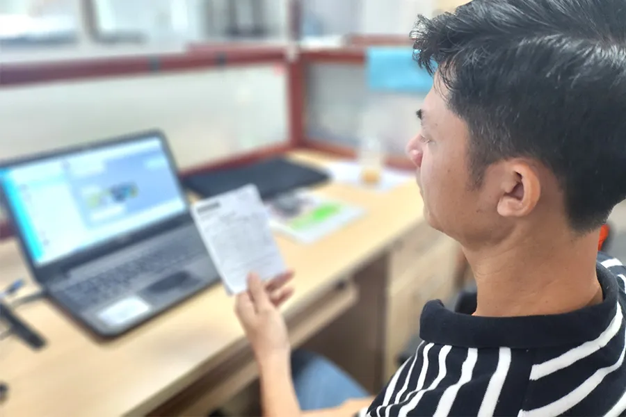 Một phụ huynh đang đóng học phí cho con qua phần mềm sau khi nhận được phiếu báo thu từ nhà trường