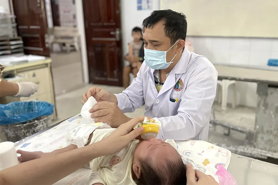 BS Huỳnh Mạnh Nhi đang bó bột, điều trị bàn chân khoèo cho con của chị Vy.