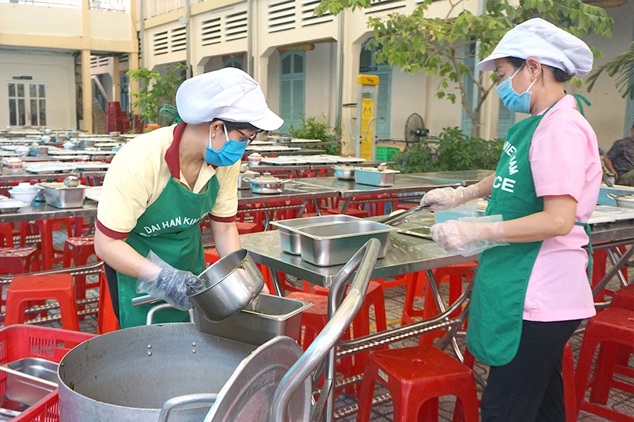 Nhân viên đang chuẩn bị bữa ăn bán trú cho học sinh Trường THCS Võ Trường Toản, quận 1, TP.HCM. Ảnh: NGUYỄN QUYÊN w-P13_tien-an-ban-tru_h1.jpg
