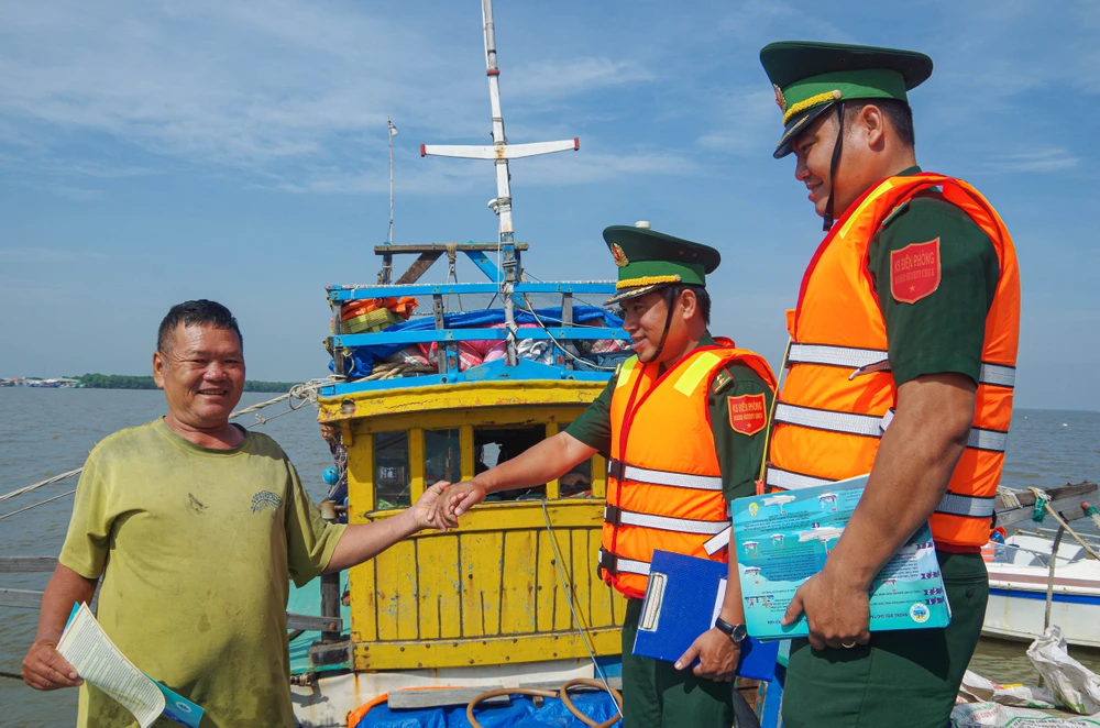 Hiểu được tầm quan trọng của việc chống khai thác IUU, nhiều ngư dân vui vẻ khi nhận tờ rơi tuyên truyền từ các chiến sĩ biên phòng. Ảnh: THUẬN VĂN Tiền Giang cùng cả nước quyết gỡ thẻ vàng IUU