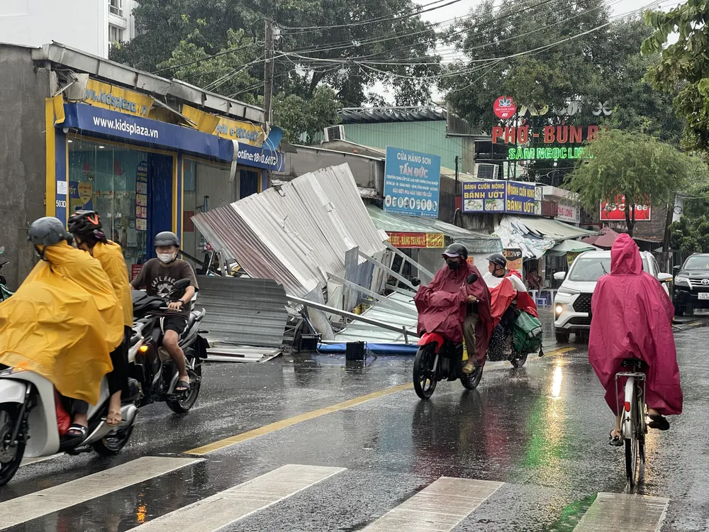 Chiều 18-7, một bảng hiệu trên đường Nguyễn Văn Quá (phường Đông Hưng Thuận, quận 12) bất ngờ đổ sập xuống đường do mưa lớn. Ngay sau đó, lực lượng chức năng của địa phương đã có mặt, xử lý hiện trường. Ảnh: TRẦN MINH Rot-bang-quang-cao_19-7.jpg