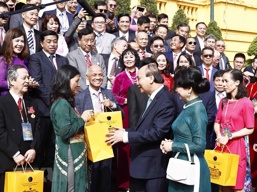 Chủ tịch nước Nguyễn Xuân Phúc tặng quà lưu niệm cho đại biểu kiều bào dự Chương trình Xuân Quê hương 2023, tại Phủ Chủ tịch. Ảnh: TTXVN Chủ tịch nước Nguyễn Xuân Phúc và Phu nhân chụp ảnh chung với các đại biểu kiều bào dự Chương trình Xuân Quê hương 2023, tại Phủ Chủ tịch. Ảnh: TTXVN