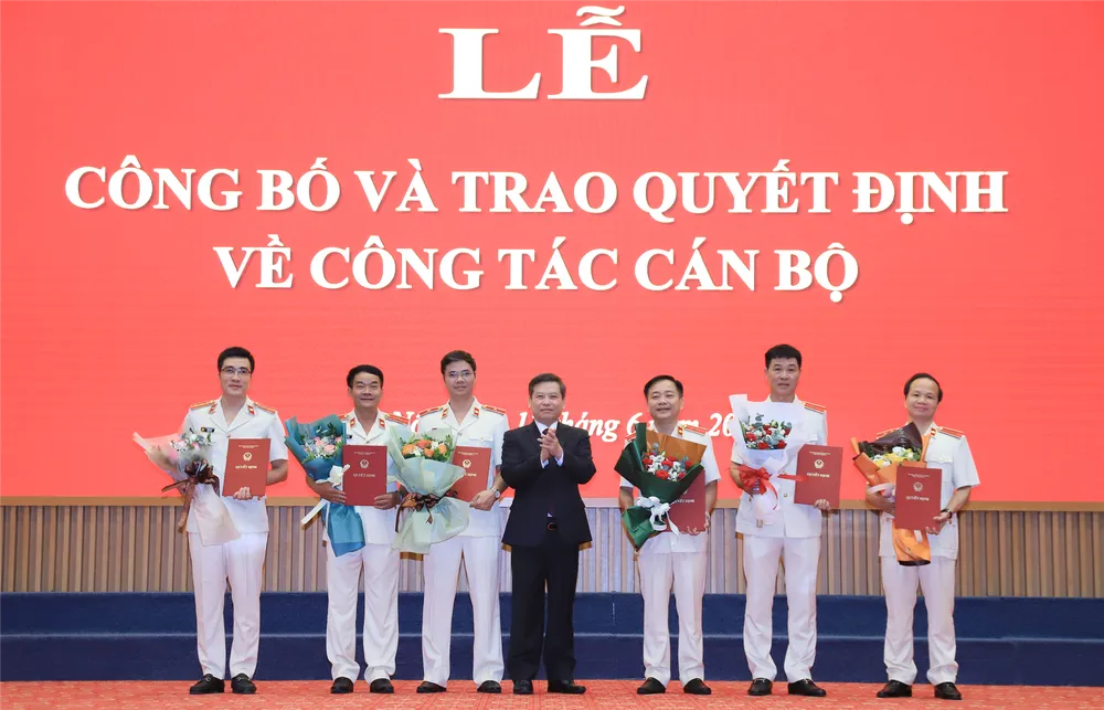 Viện trưởng VKSND tối cao Lê Minh Trí trao quyết định, tặng hoa chúc mừng lãnh đạo các vụ. Ảnh: VKS