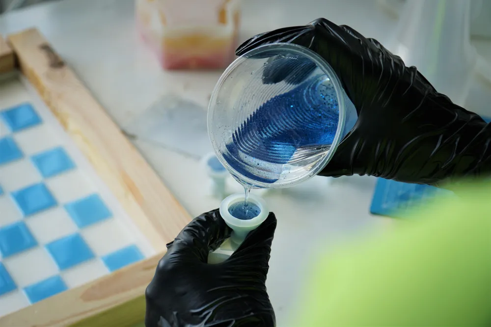 Chị Trâm Anh đang đổ khuôn cho một quân cờ vua. Ảnh: BẢO PHƯƠNG Chị Trâm Anh đang đổ khuôn cho một quân cờ vua. Ảnh: BẢO PHƯƠNG