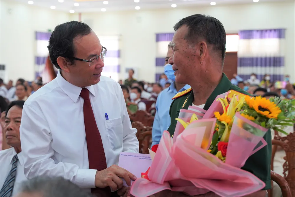 Bí thư Nguyễn Văn Nên trò chuyện với Anh hùng lực lượng vũ trang Tô Văn Đực. Ảnh: BẢO PHƯƠNG