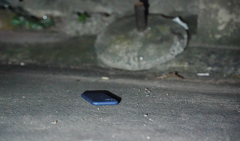 Chiếc điện thoại của nạn nhân bị quăng dưới gầm ô tô trong quá trình bỏ chạy. Ảnh: BẢO PHƯƠNG