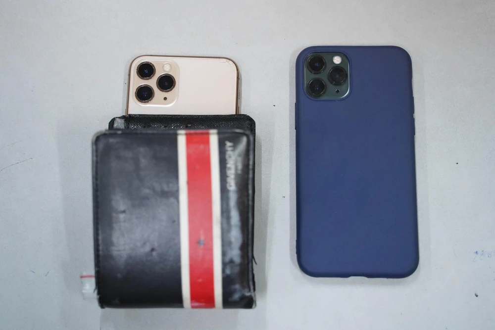 Ngoài chiếc xe máy, công an còn thu giữ được một ví da và điện thoại của Thiện (bên trái), một điện thoại Iphone 11 Pro màu xanh của nạn nhân (bên phải). Ảnh: BẢO PHƯƠNG