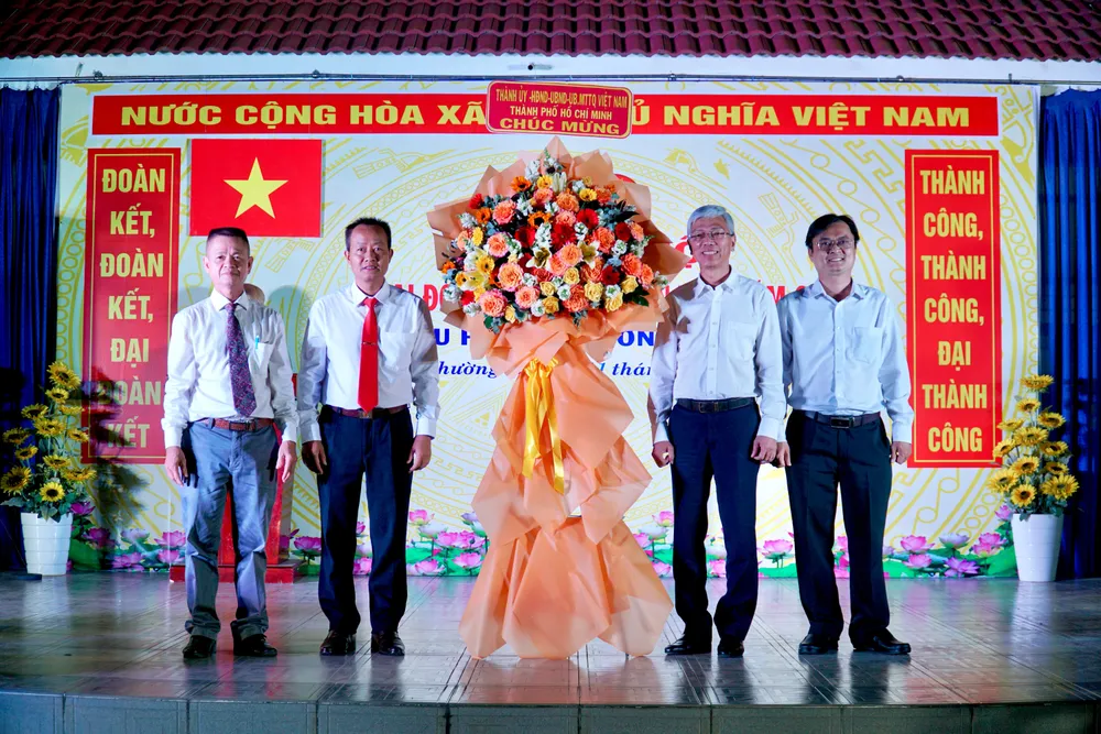 Phó Chủ tịch UBND TP.HCM Võ Văn Hoan trao hoa chúc mừng cho địa phương. Ảnh: BẢO PHƯƠNG