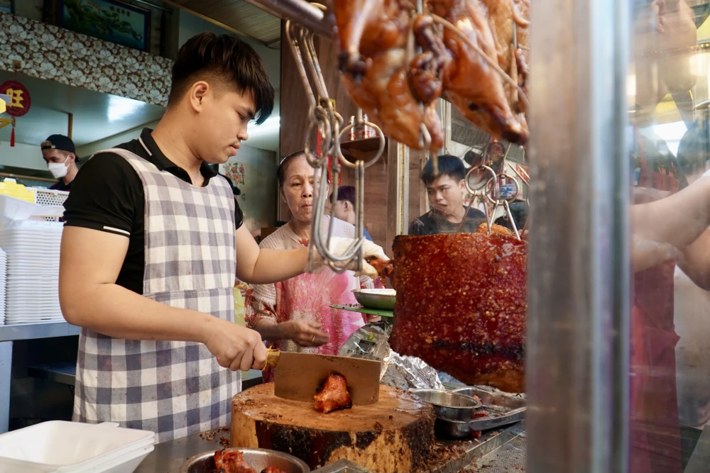 Hơn chục nhân viên của tiệm vịt quay làm việc xuyên suốt từ đêm hôm trước để kịp giao hàng khách đã đặt trước. Sáng ngày vía Thần Tài, tiệm bắt đầu mở cửa phục vụ khách mua lẻ. Ảnh: PHƯƠNG ĐẶNG