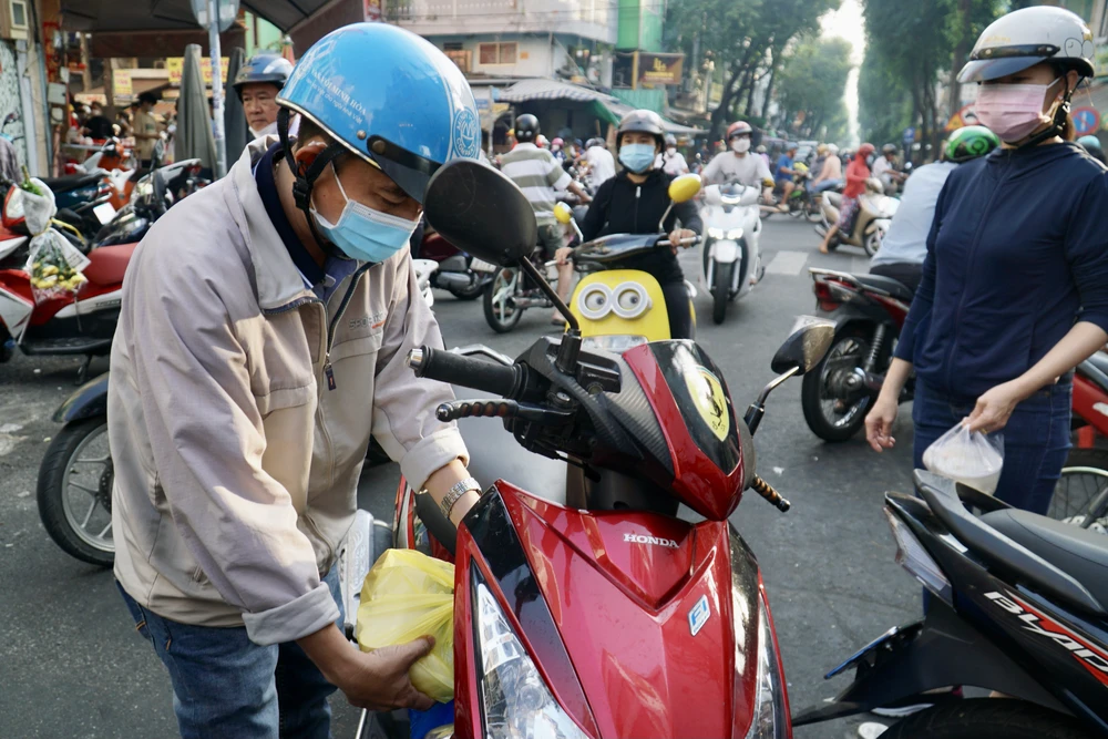 Anh Nguyễn Văn Hùng (quận Bình Tân, TP.HCM) cho biết năm nào anh cũng tranh thủ đến sớm để mua vì sợ chen lấn. "Năm nào chỗ này cũng đông nghẹt người, tôi đến từ 7 giờ sáng nhưng cũng phải chờ rất lâu mới đến lượt, nhiều người trước tôi đến từ 5 giờ, 6 giờ rồi. Chỗ này bán ngon nên tôi đến mua sau khi cúng xong sẽ cùng gia đình ăn"- anh Hùng chia sẻ. Ảnh: PHƯƠNG ĐẶNG