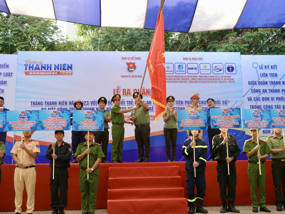 Thiếu tướng Trần Đức Tài, Phó Giám đốc CATP, trao cờ lệnh xuất quân cho Đại úy Đặng Văn Thắng, Bí thư Đoàn CATP. Ảnh: PĐ