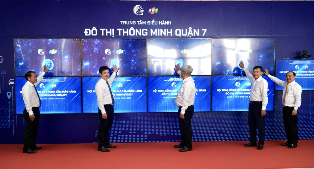 Đại diện Sở TT&amp;TT TP.HCM cùng lãnh đạo quận 7, Tập đoàn FPT nhấn nút ra mắt Trung tâm điều hành đô thị thông minh. Ảnh: BẢO PHƯƠNG
