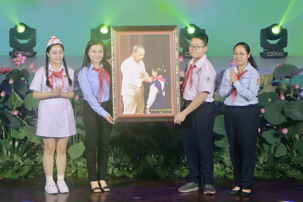 Bí thư Trung ương Đoàn, Chủ tịch Hội Đồng đội Trung ương Nguyễn Phạm Duy Trang (thứ hai từ trái sang) trao tặng bức tranh Bác Hồ với thiếu nhi đến Hội Đồng đội TP.HCM. Ảnh: PHƯƠNG ĐẶNG