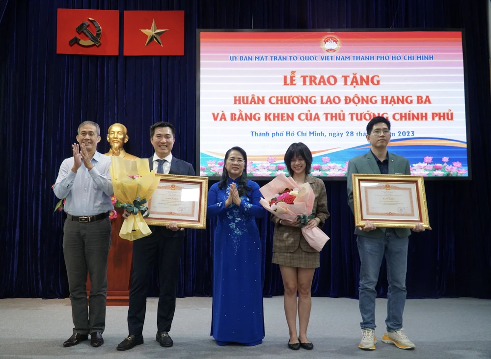 Trưởng Ban công tác phía Nam Ủy ban Trung ương MTTQ Việt Nam Võ Văn Thiện (bìa trái) và Chủ tịch Ủy ban MTTQ Việt Nam TP.HCM Trần Kim Yến (giữa) trao bằng khen của Thủ tướng cho hai tập thể. Ảnh: BẢO PHƯƠNG