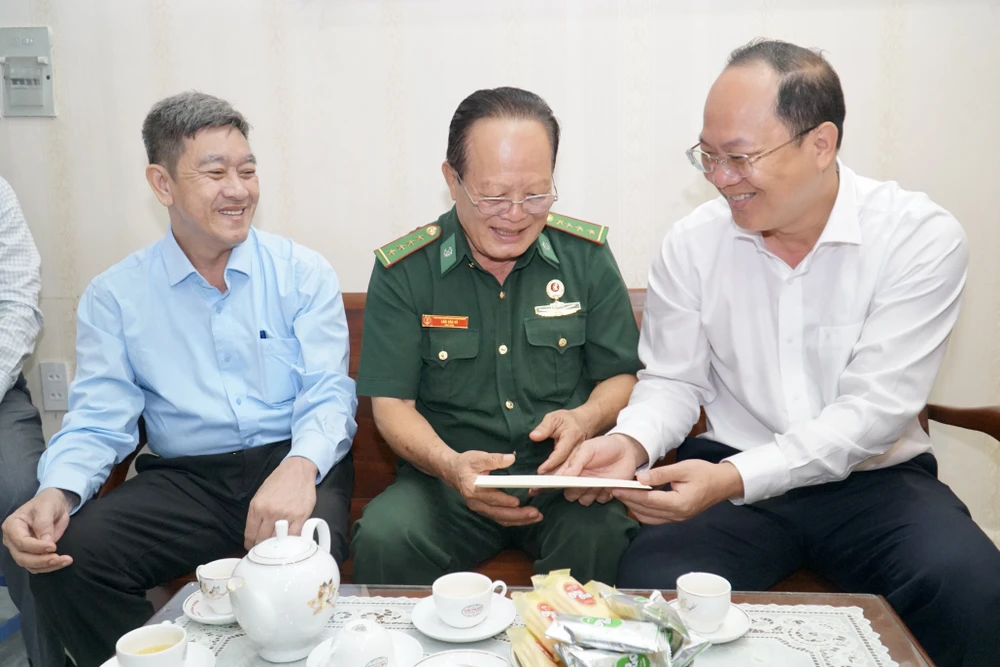 Phó Bí thư Thành ủy TP.HCM Nguyễn Hồ Hải (bìa phải) trao quà cho ông Lâm Văn Vô. Ảnh: BẢO PHƯƠNG