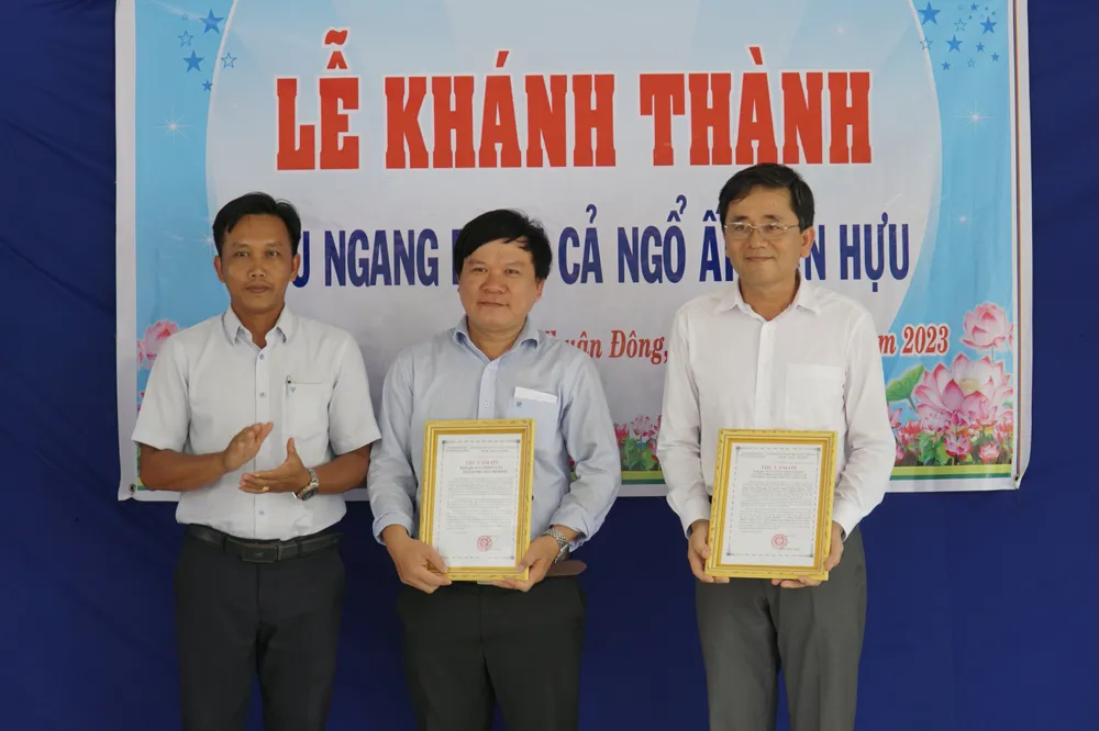 Lãnh đạo xã trao thư cảm ơn cho nhà tài trợ. Ảnh: BẢO PHƯƠNG